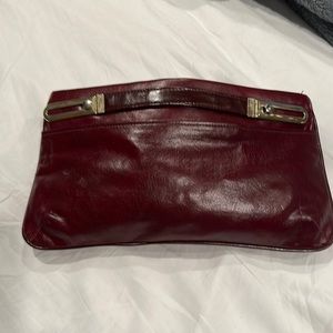 Maroon leather clutch with optional arm straps